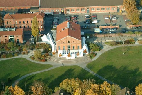 Blick von oben auf die Alte Reithalle, ringsum mit Zelten eingerichtet